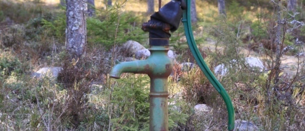 Ett  handtag på en pump tillhörande en brunn.