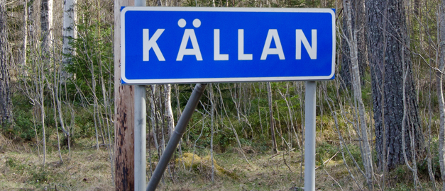 En skylt med ordet "Källan", som är namnet på några gårdar i Dalarna.
