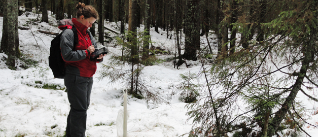 En person står och antecknar efter att ha mätt grundvattennivån i ett grundvattenrör i Kindla.