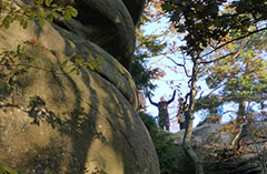 En person står uppe på ett berg. Foto.