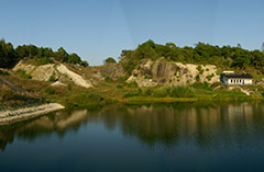 Vy med berg, vatten och gräs. Foto.