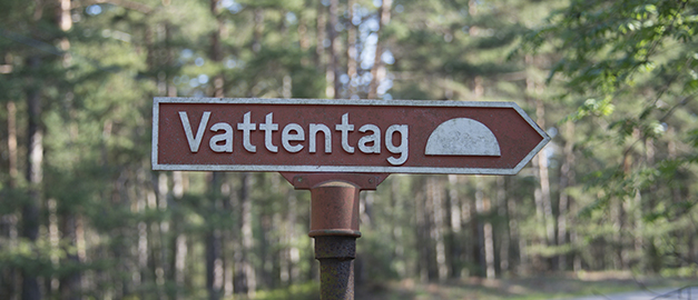 På bilden syns en brun skylt som det står vattentag på.