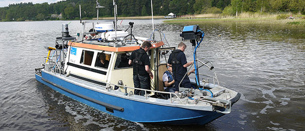 På bilden syns SGU:s båt Ugglan. På båten står några män som arbetar med provtagning av Fyrisån i Uppsala, Sverige. Foto.