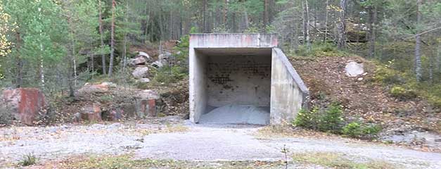 På bilden syns en byggnad i betong. Byggnaden är till för att samla kulor från skjutfältet i Hugelsta.